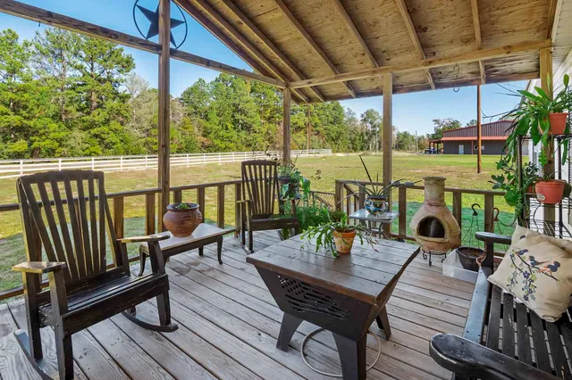 a view of a balcony with chairs and wooden floor