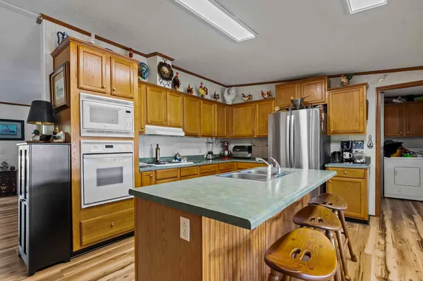 a kitchen with stainless steel appliances granite countertop a refrigerator a stove and a sink
