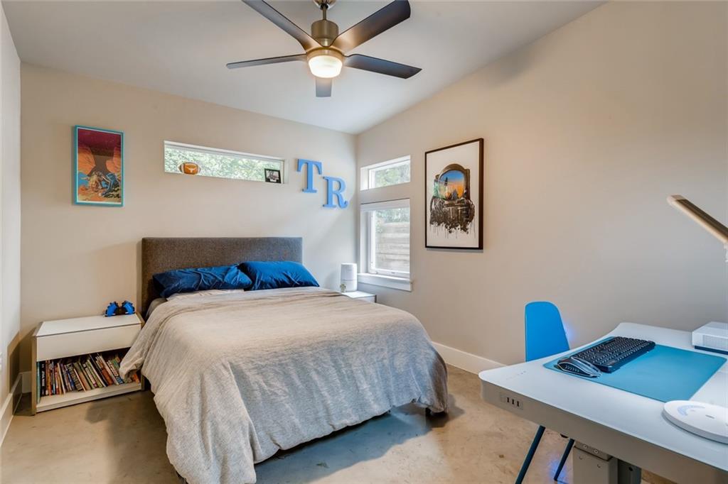 1142 Eleanor Street, Unit 2 Austin, TX 78721 - Photo 20 of 24 A comfortable bedroom with a vaulted ceiling and concrete flooring offers a blend of relaxation and modern design.