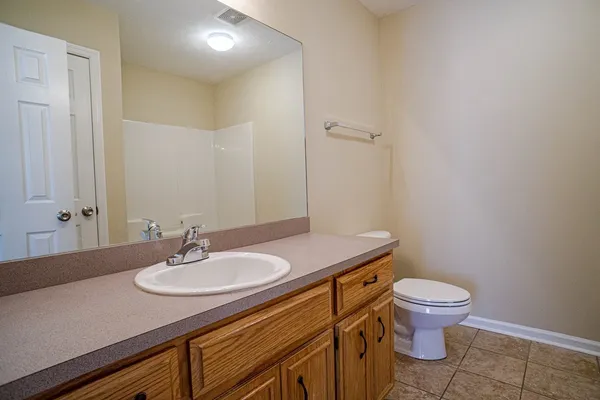 a bathroom with a granite countertop sink a toilet and a mirror
