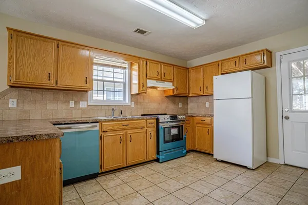 a kitchen with granite countertop cabinets stainless steel appliances and a sink