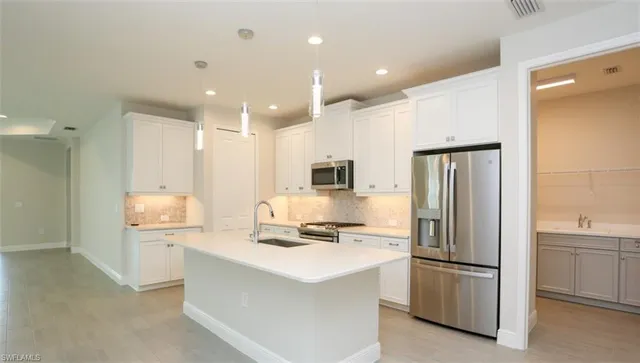a kitchen with stainless steel appliances a refrigerator stove and microwave