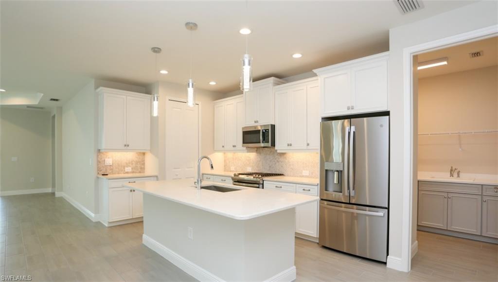 a kitchen with stainless steel appliances a refrigerator stove and microwave