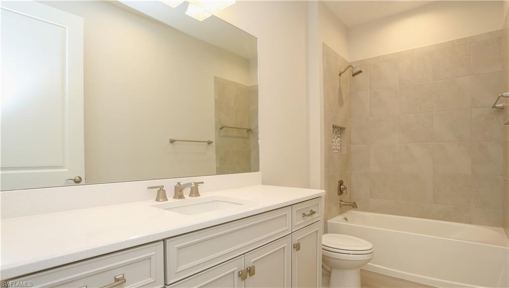 2428 Ariane Drive Naples, FL 34112 - Photo 11 of 23 a bathroom with a granite countertop sink a toilet and shower