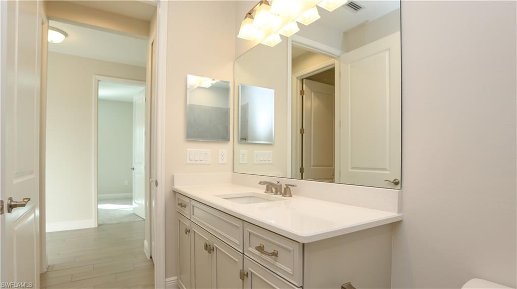 2428 Ariane Drive Naples, FL 34112 - Photo 12 of 23 a bathroom with a sink vanity and a mirror
