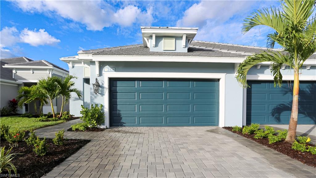 2428 Ariane Drive Naples, FL 34112 - Photo 14 of 23 a front view of a house with a yard and garage