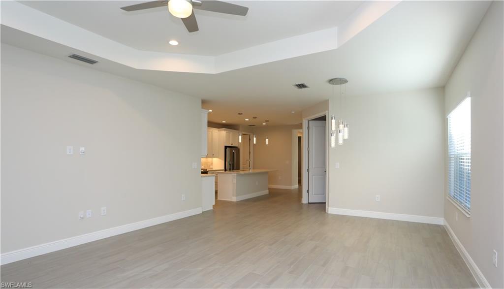 2428 Ariane Drive Naples, FL 34112 - Photo 4 of 23 wooden floor in an empty room with a window