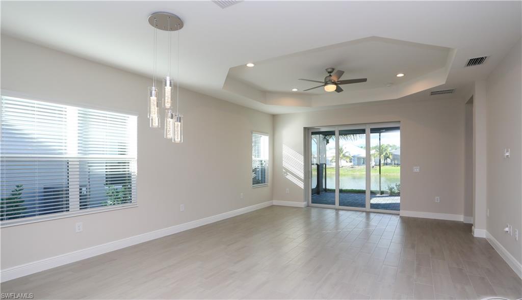 2428 Ariane Drive Naples, FL 34112 - Photo 6 of 23 an empty room with windows and chandelier fan