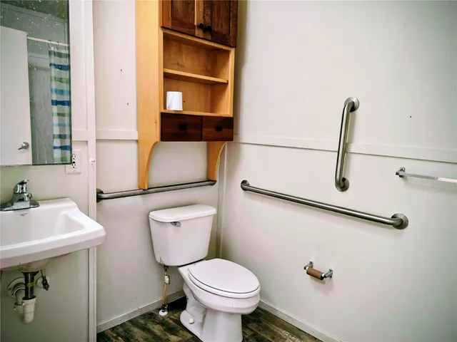 a bathroom with a toilet sink and mirror