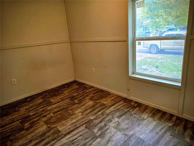 a view of a room with wooden floor and a window