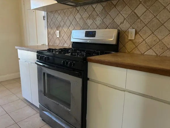 a stove top oven sitting inside of a kitchen
