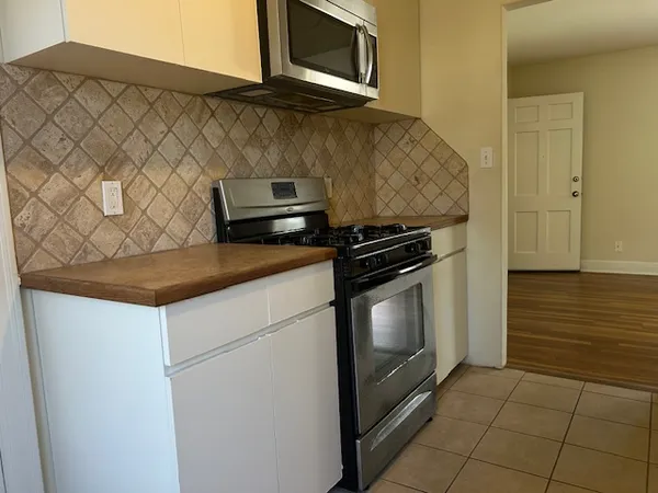 a kitchen with granite countertop white cabinets and black appliances