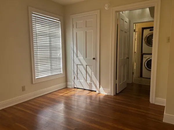a view of a hallway with wooden floor and a window