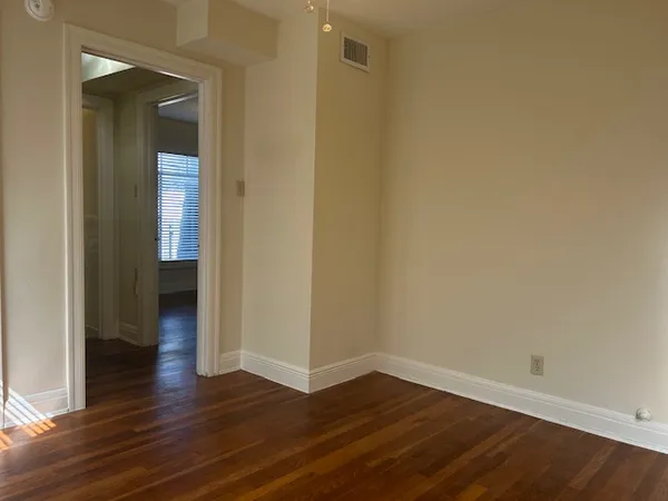 an empty room with wooden floor and closet