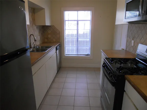 a kitchen with a sink a stove and cabinets