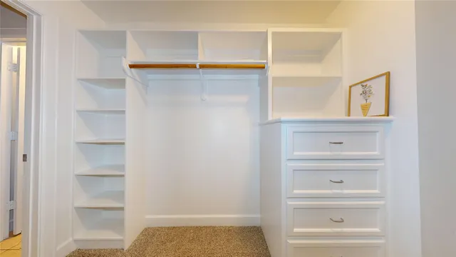 a view of walk in closet with clothes