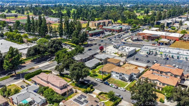 an aerial view of a city with lots of residential buildings ocean and mountain view in back