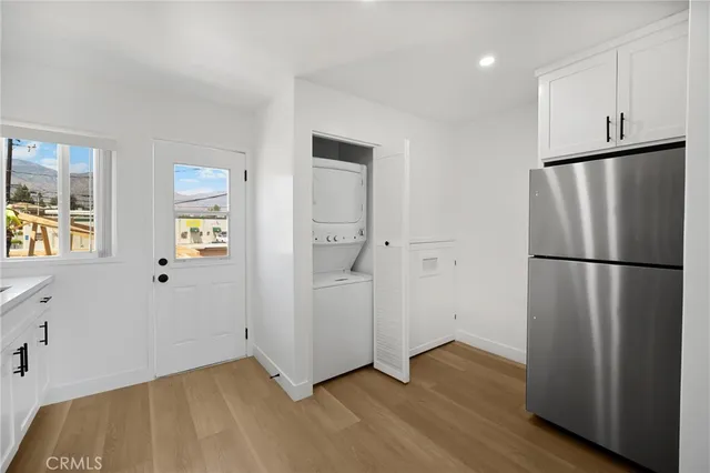 a view of an empty room with wooden floor and a cabinet