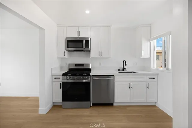 a kitchen with stainless steel appliances granite countertop a stove and a sink