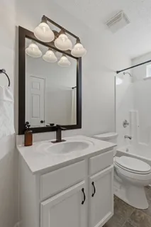a bathroom with a sink vanity toilet and shower
