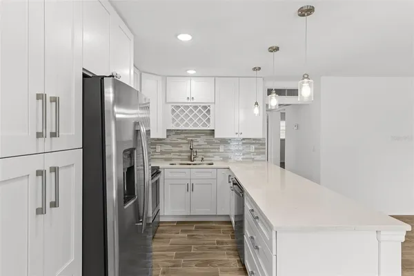 a kitchen with a sink a refrigerator and a stove