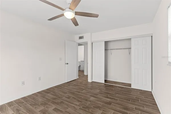 a view of empty room with wooden floor