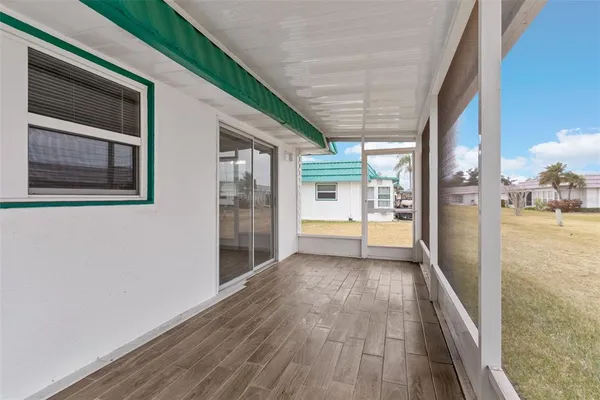 a view of a hallway with wooden floor and a kitchen