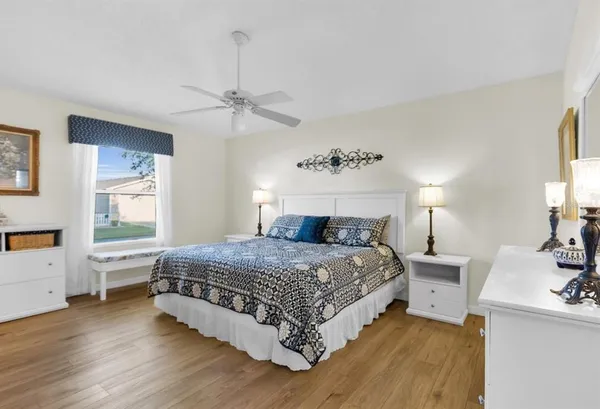 a bedroom with a bed chandelier and a window