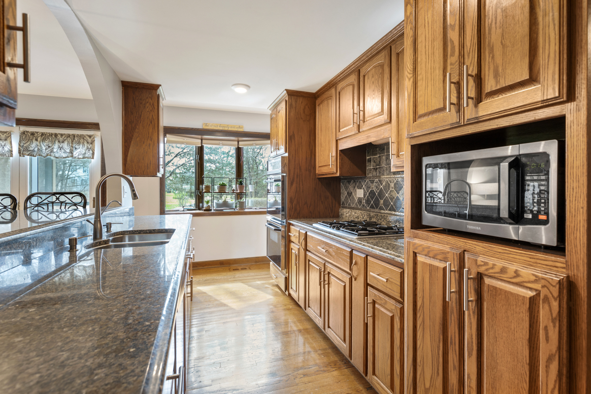 860 Highland Road Frankfort, IL 60423 - Photo 8 of 18 a kitchen with stainless steel appliances granite countertop a stove a sink and a microwave