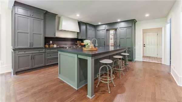 a kitchen with stainless steel appliances granite countertop a table chairs stove and refrigerator