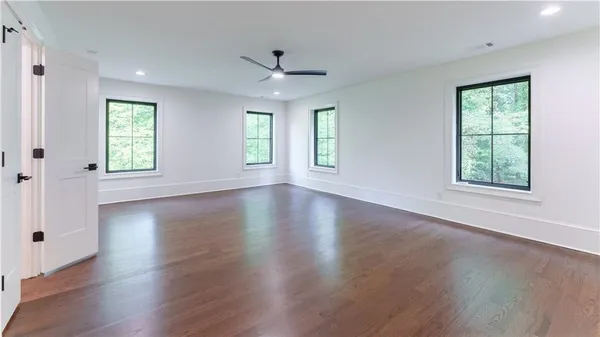 an empty room with wooden floor and windows
