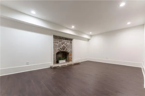 an empty room with wooden floor and window