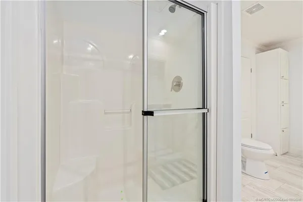 a bathroom with a granite countertop sink toilet a mirror and shower