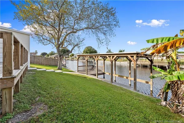 a view of a house with a big yard and large trees