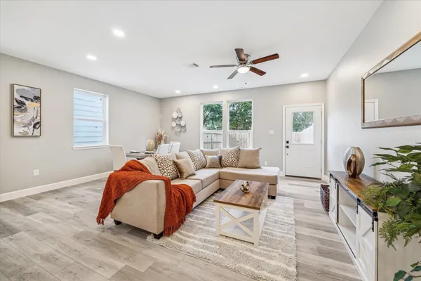a living room with furniture ceiling fan and a window