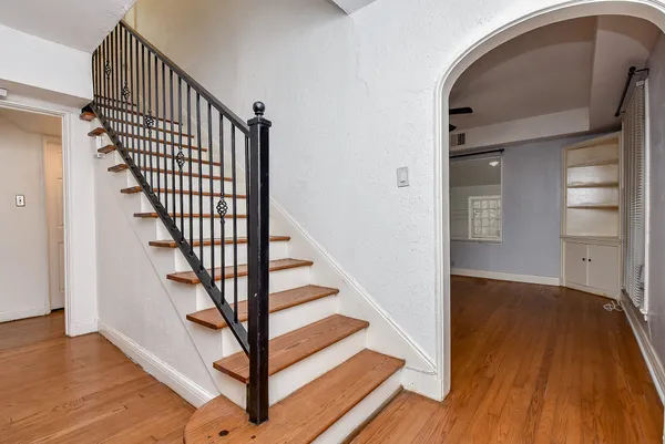 a view of a hallway with wooden floor and entryway