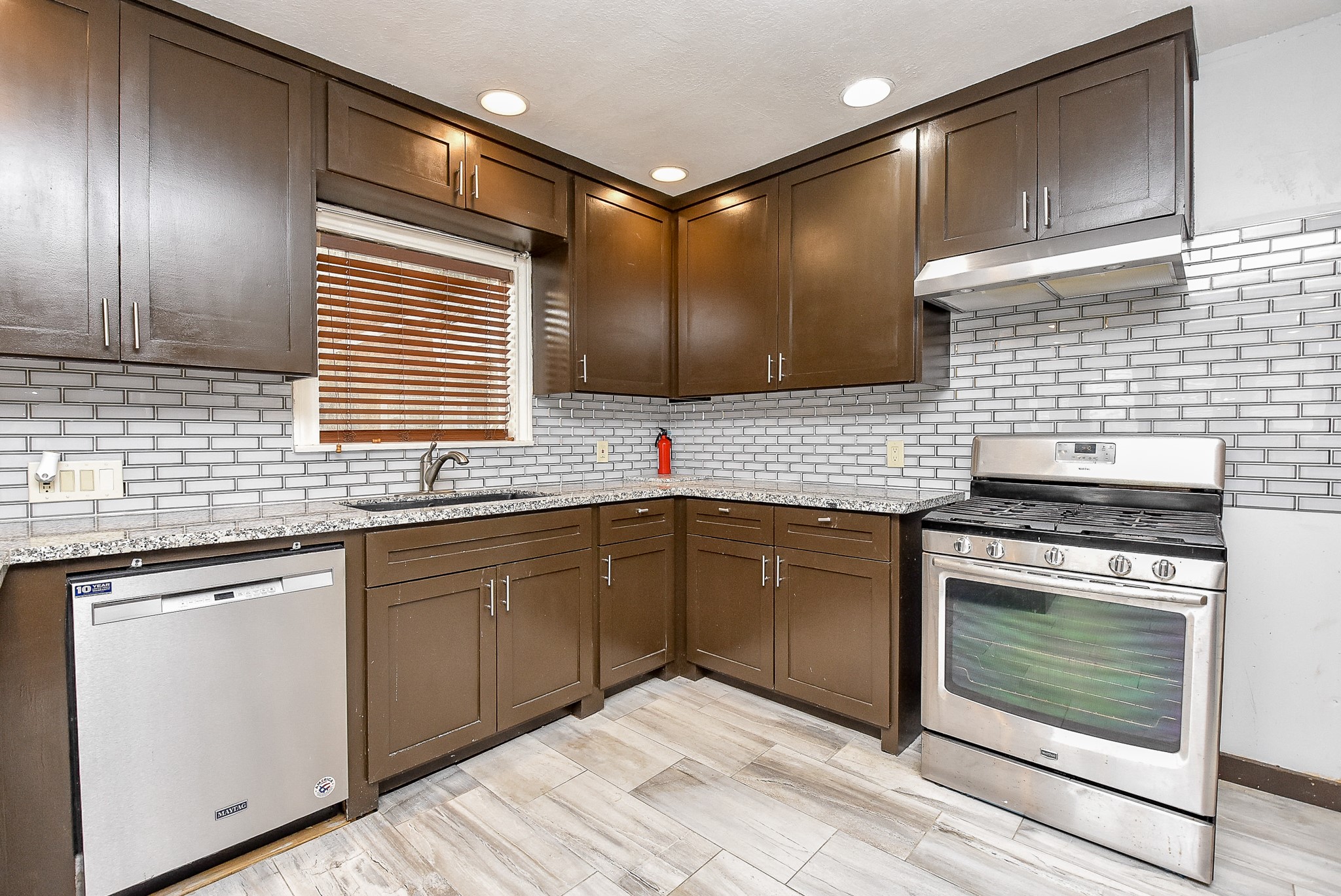 4916 Old Spanish Trail Houston, TX 77021 - Photo 9 of 32 a kitchen with stainless steel appliances granite countertop cabinets sink and wooden floor