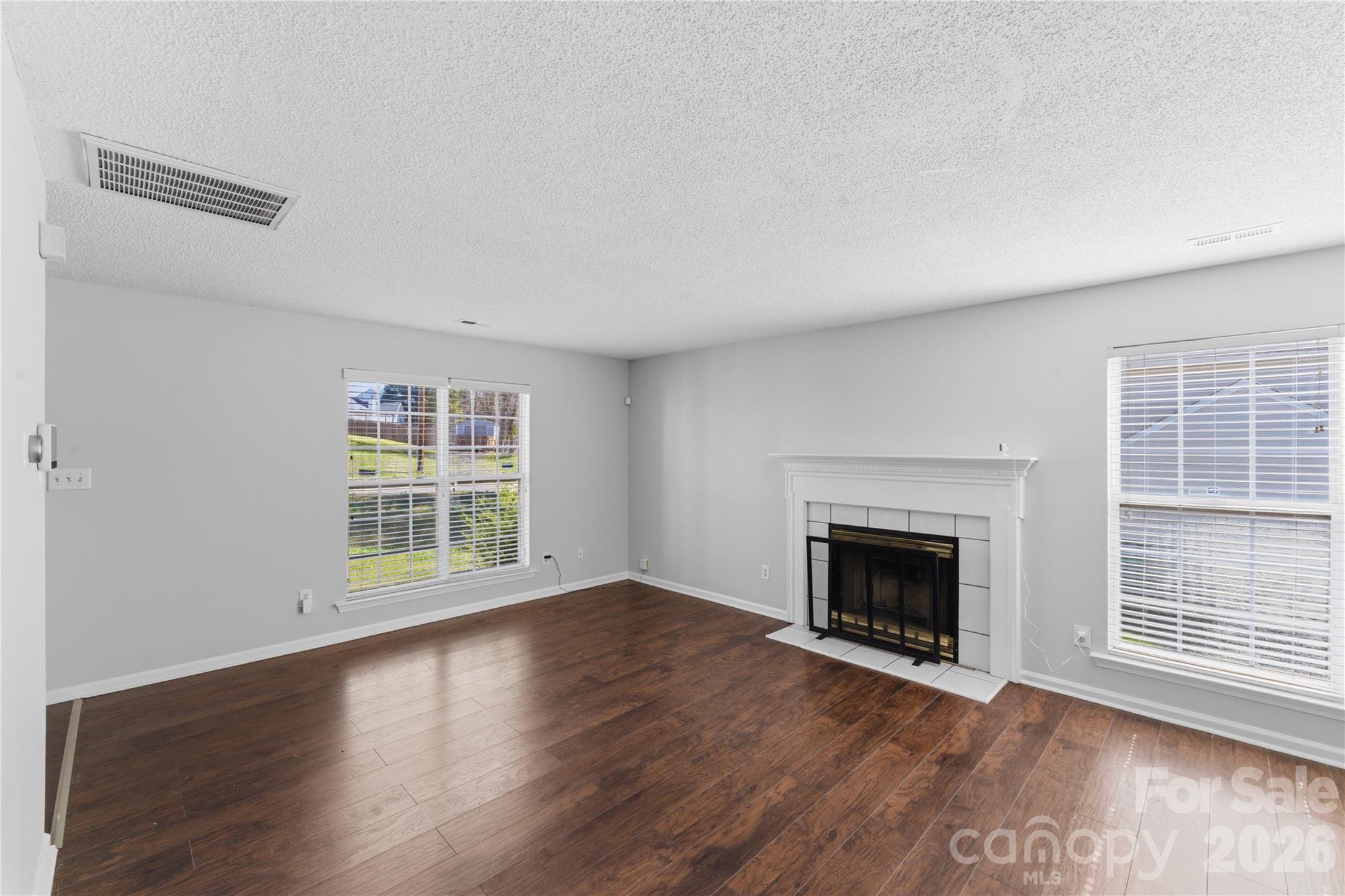 8608 Moody Road Charlotte, NC 28215 - Photo 27 of 33 an empty room with wooden floor fireplace and windows
