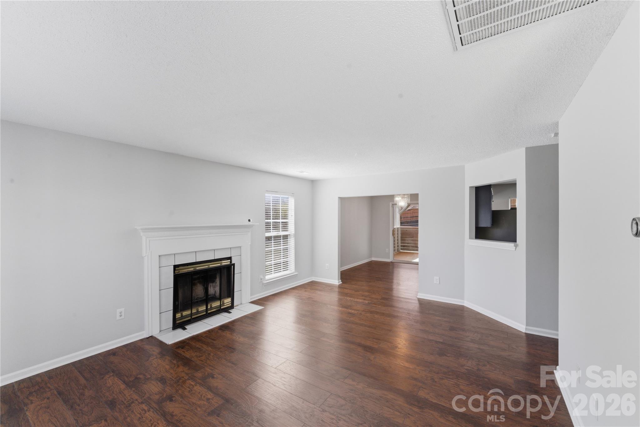 8608 Moody Road Charlotte, NC 28215 - Photo 5 of 33 an empty room with wooden floor fireplace and windows