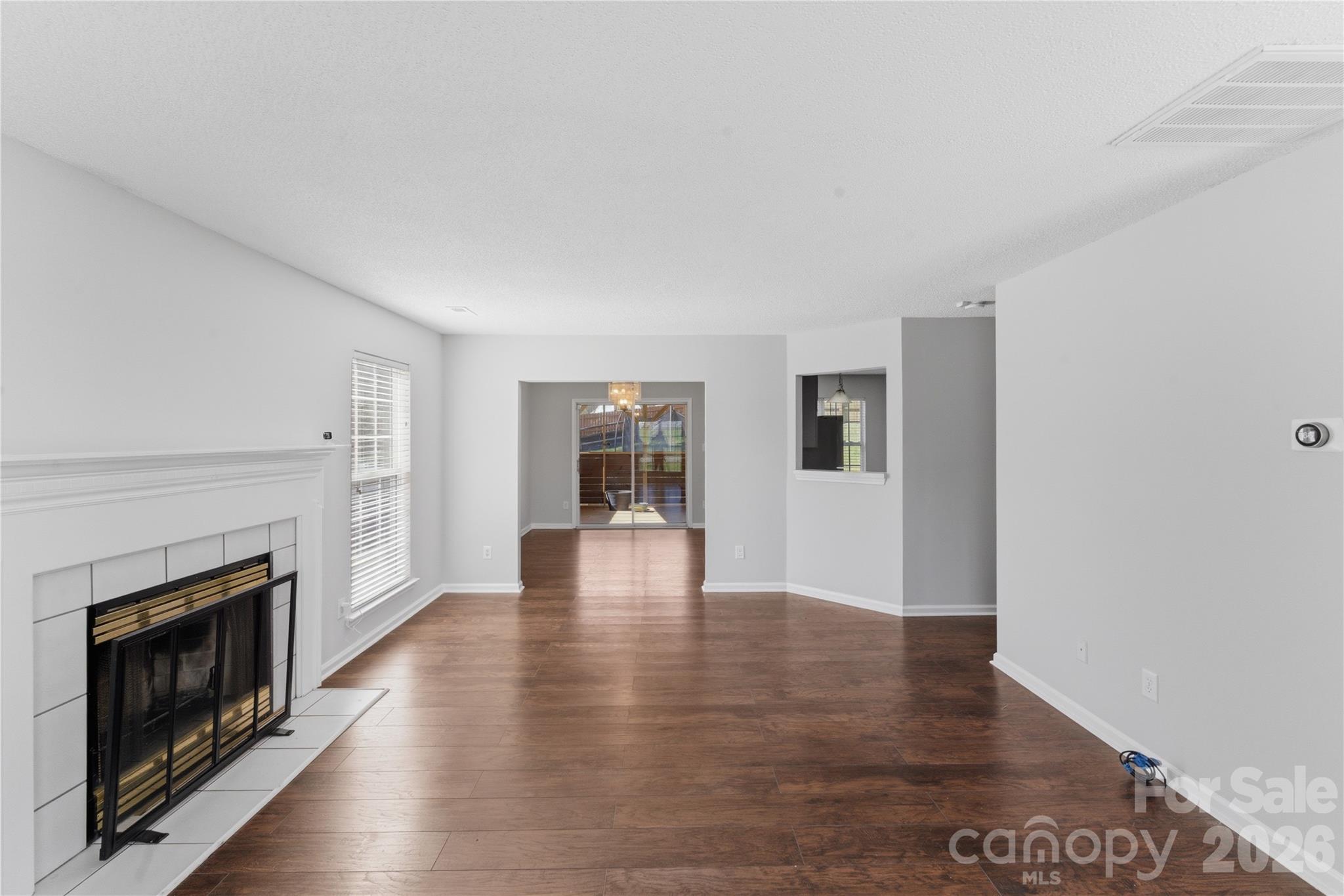 8608 Moody Road Charlotte, NC 28215 - Photo 6 of 33 a view of an empty room with wooden floor fireplace and a window