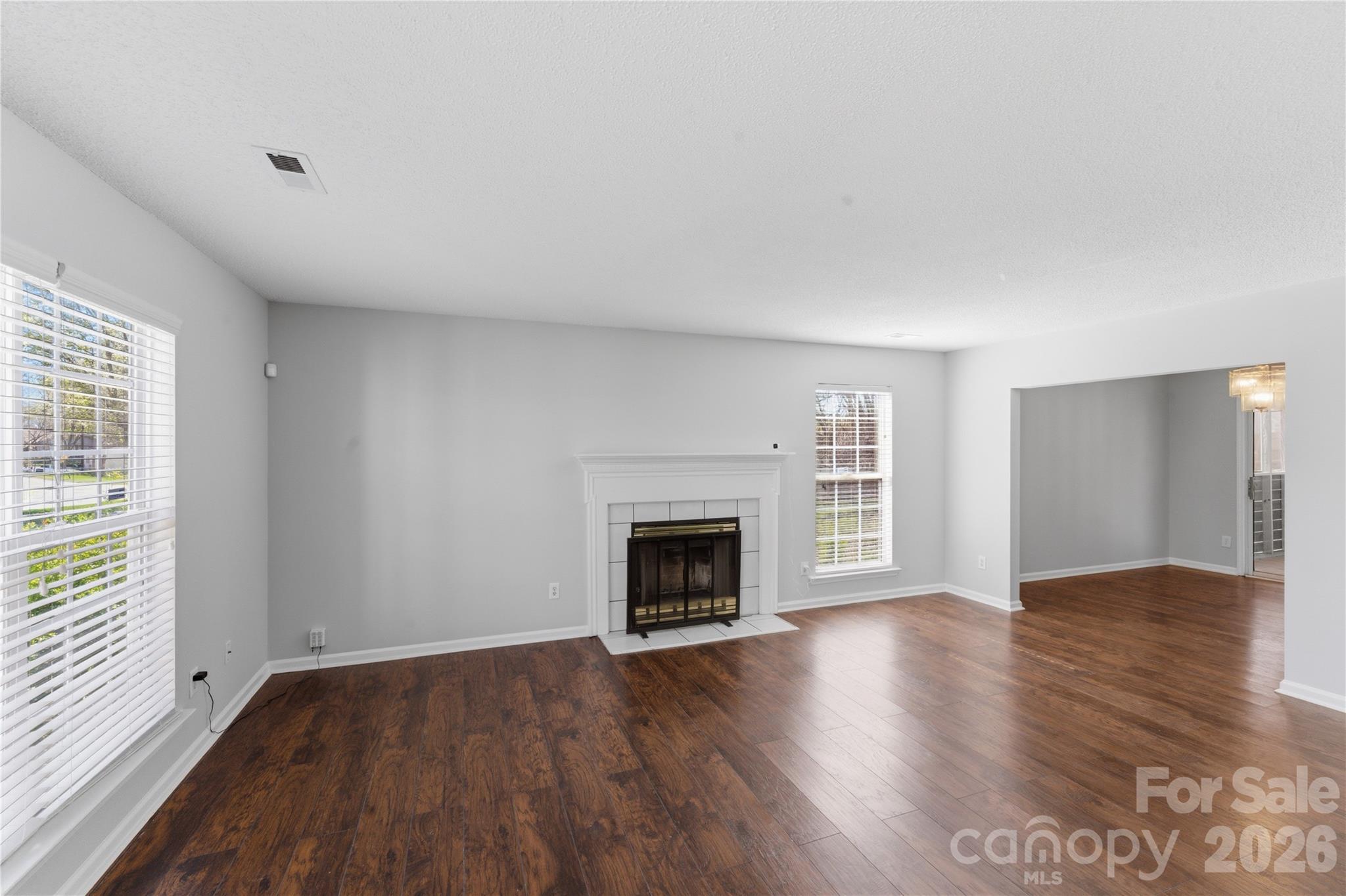 8608 Moody Road Charlotte, NC 28215 - Photo 7 of 33 an empty room with wooden floor fireplace and windows