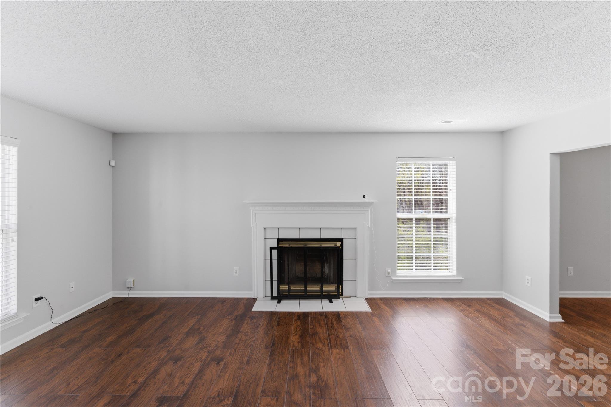 8608 Moody Road Charlotte, NC 28215 - Photo 10 of 33 an empty room with wooden floor fireplace and windows