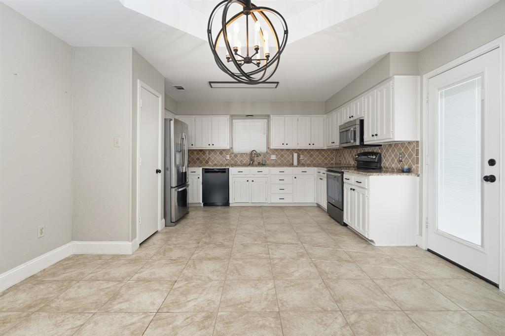 7205 Windcrest Court East North Richland Hills, TX 76182 - Photo 13 of 35 a large white kitchen with a stove a sink and a refrigerator