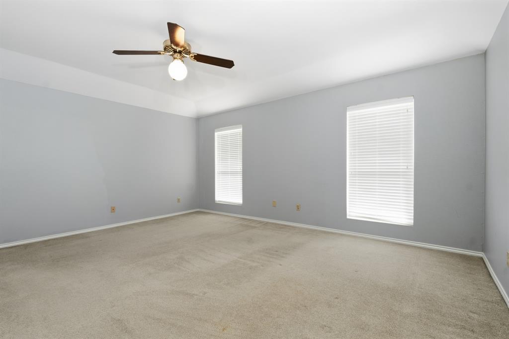 7205 Windcrest Court East North Richland Hills, TX 76182 - Photo 18 of 35 an empty room with a window and a ceiling fan