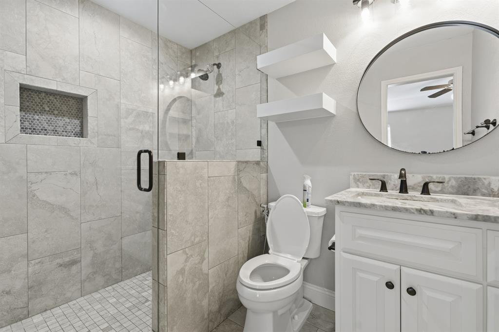 7205 Windcrest Court East North Richland Hills, TX 76182 - Photo 19 of 35 a bathroom with a granite countertop toilet sink vanity and mirror