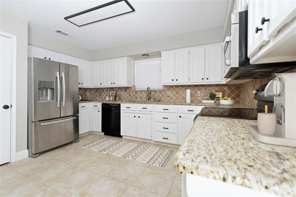 7205 Windcrest Court East North Richland Hills, TX 76182 - Photo 4 of 35 a kitchen with a refrigerator sink and cabinets