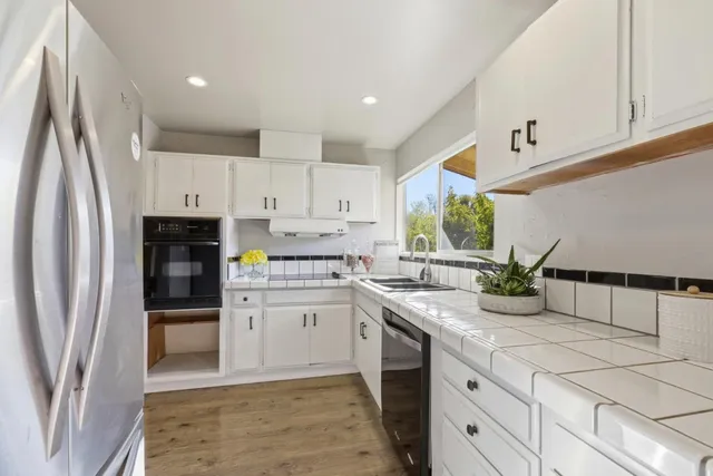 a kitchen with stainless steel appliances granite countertop a refrigerator sink and stove