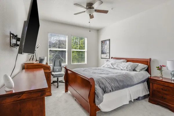 a bedroom with a bed and a flat tv screen on the dresser