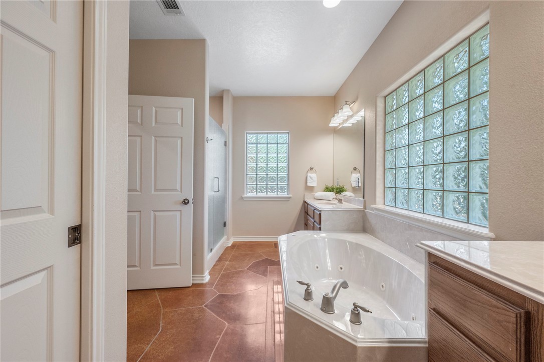 4960 Drake Drive College Station, TX 77845 - Photo 17 of 31 Full bathroom featuring a separate shower, double vanity, and a jetted tub