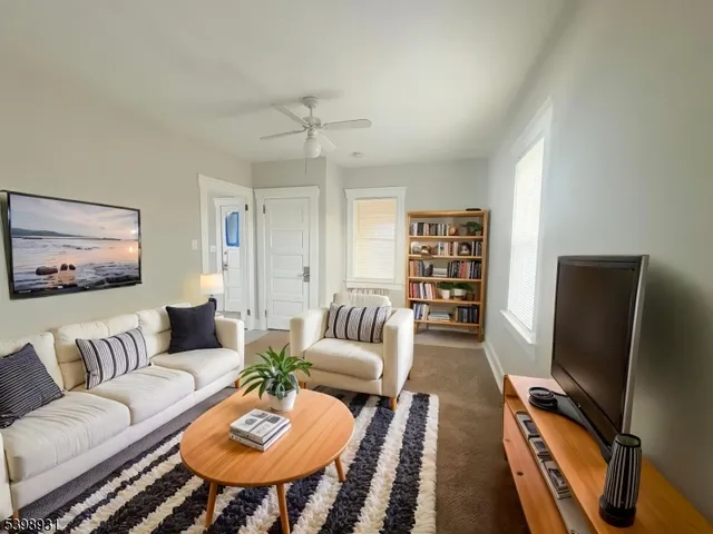 a living room with furniture a rug and a flat screen tv